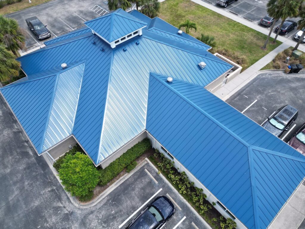 Aerial view of a blue standing seam metal roof on a commercial building